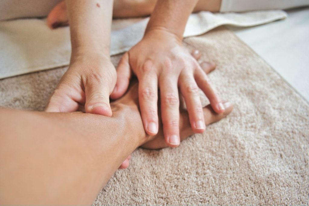 Registered massage therapist performing massage on a client's forearm and hand